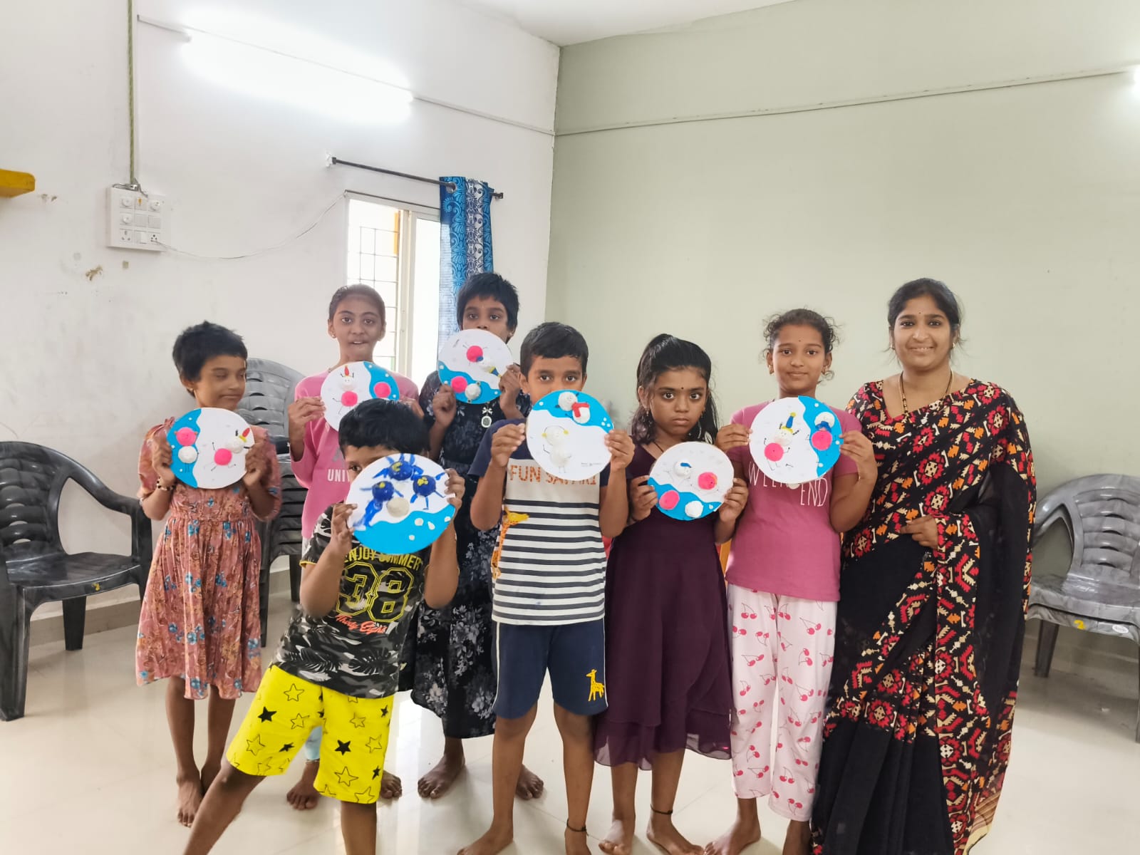 Children at the Creative Learning Center holding craft work they made